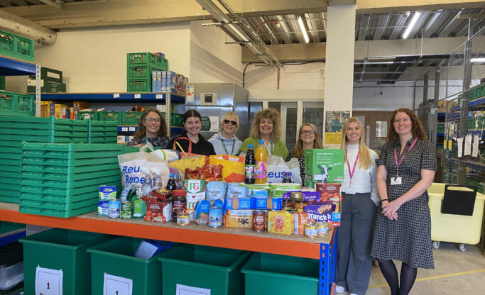 people standing in a row with food in front of them
